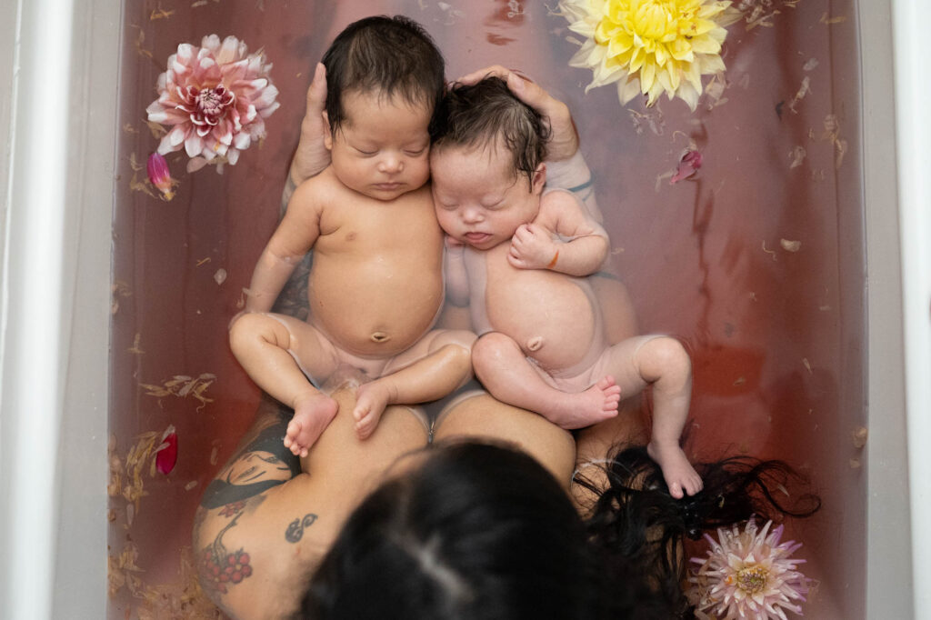 twins bathe with mom in herbal bath with flowers